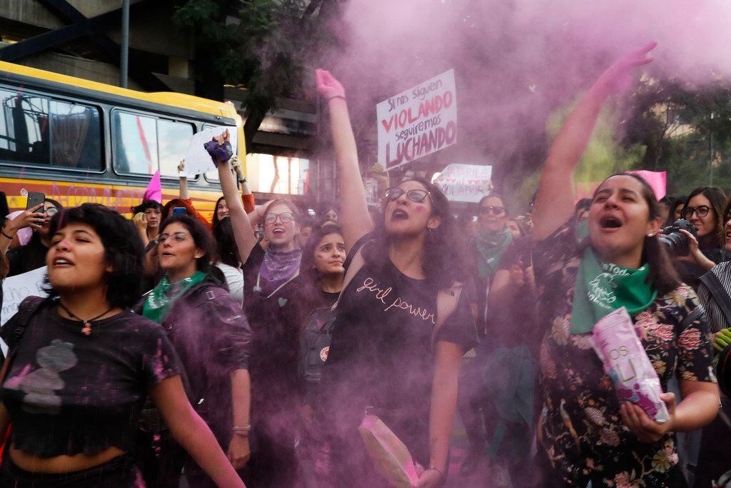 Women toss pink glitter during an August 16 protest march demanding justice safety sparked...