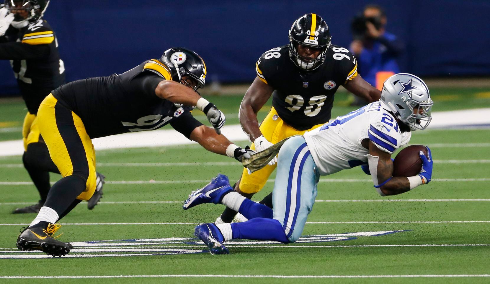 Dallas Cowboys running back Ezekiel Elliott (21) is brought down by Pittsburgh Steelers defensive end Stephon Tuitt (91) and Pittsburgh Steelers inside linebacker Vince Williams (98) during the third quarter of play at AT&T Stadium in Arlington, Texas on Sunday, November 8, 2020. (Vernon Bryant/The Dallas Morning News)