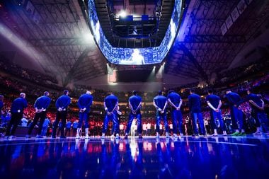 Dallas Mavericks players stand for the national anthem before Game 4 of an NBA basketball...