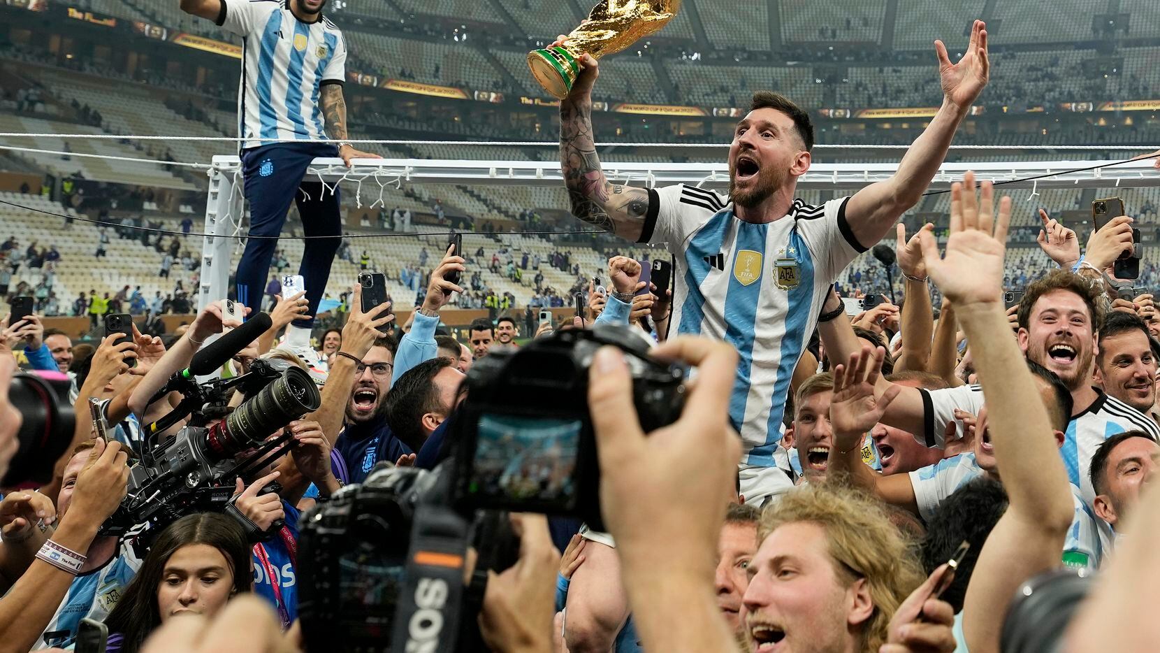El argentino Lionel Messi celebra con el trofeo ante los hinchas tras ganar el Mundial en la...