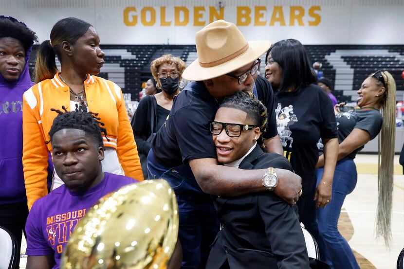 South Oak Cliff football player Danny Green Jr  (with glasses) receives a hug from his...