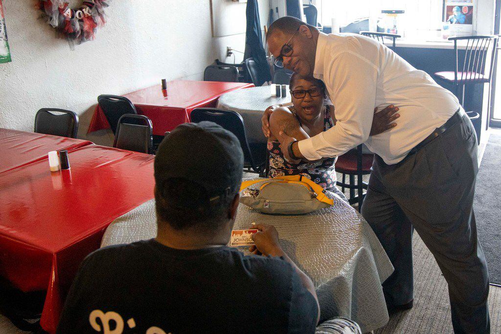 Rep. Eric Johnson embraces Jennifer Coleman as Herman Campbell looks on during a lunch stop at Blackjack Pizza on MLK Jr. Boulevard in South Dallas on May 28, 2019. (Shaban Athuman/Staff Photographer)