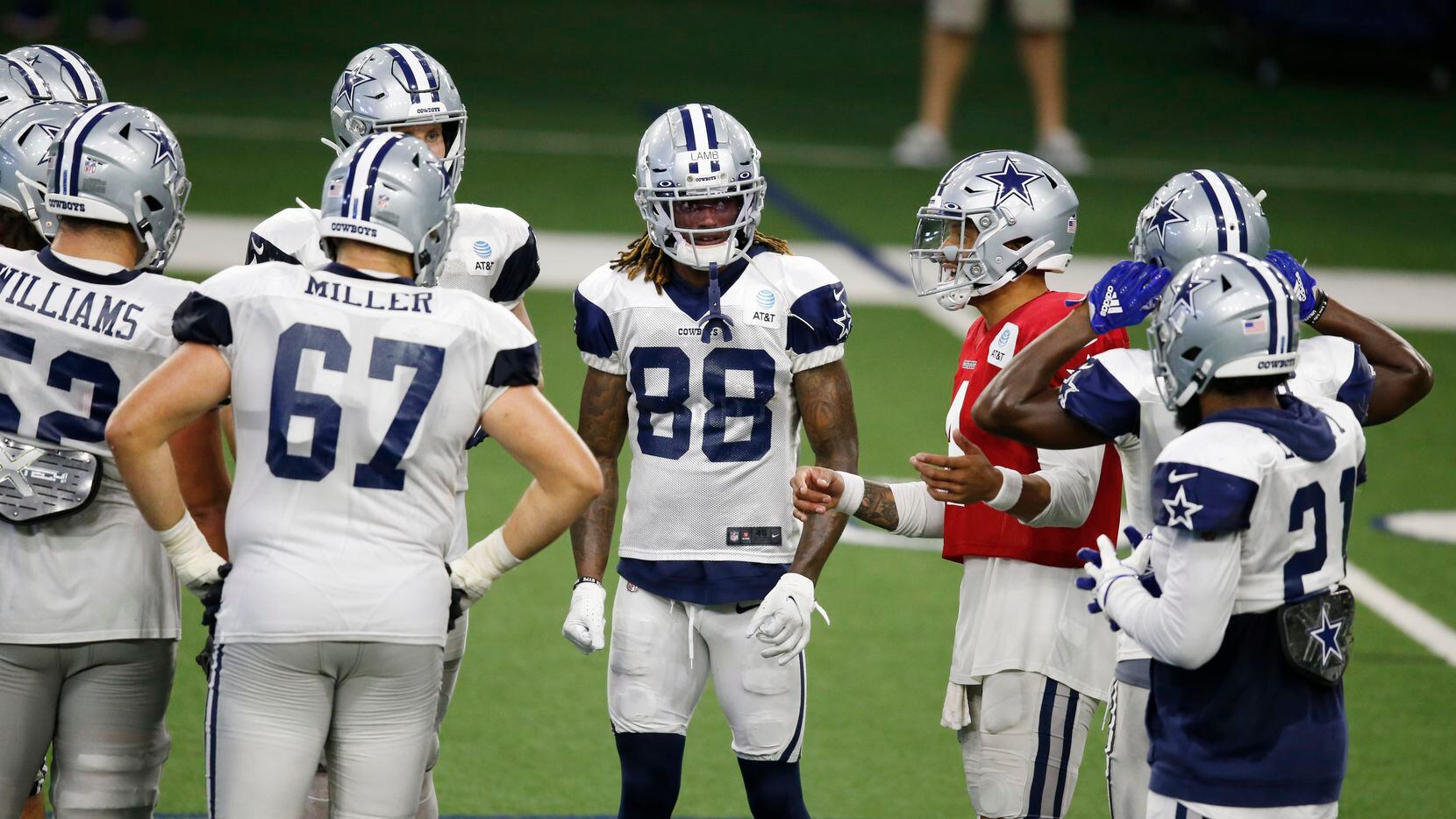 Dallas Cowboys quarterback Dak Prescott (4) talks to teammates in the huddle during training...