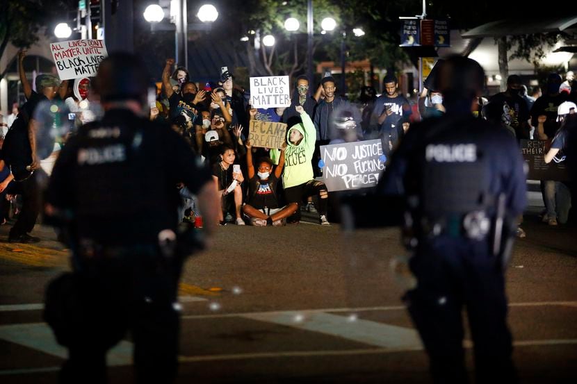 Un grupo de manifestantes gritan consignas a agentes de la Policía de Dallas en un bloqueo...