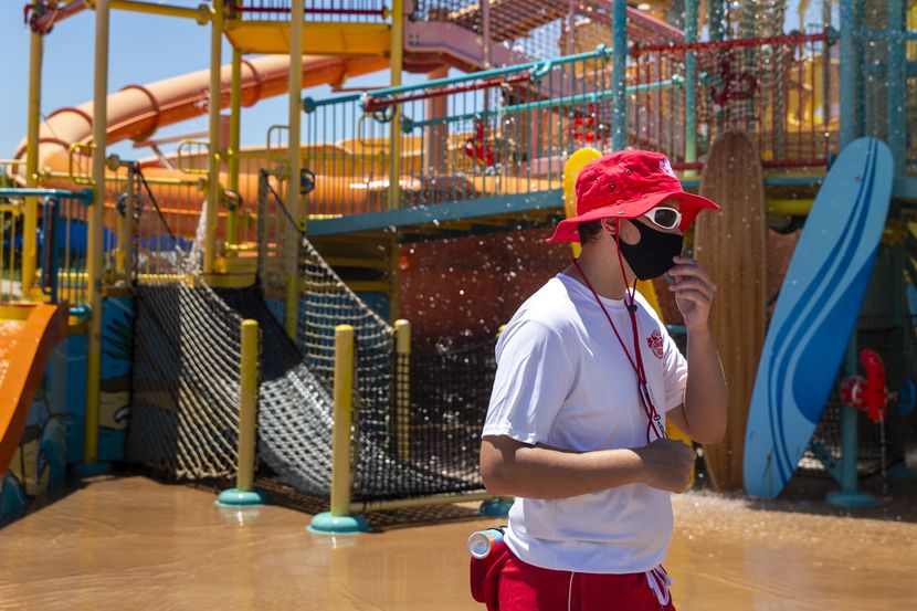Lifeguard Michael Schmidt adjusts his face mask while monitoring water attractions at the...