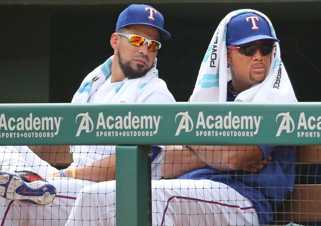 Texas Rangers Robinson Chirinos' left, and Adrian Beltre are pictured in the dugout during...