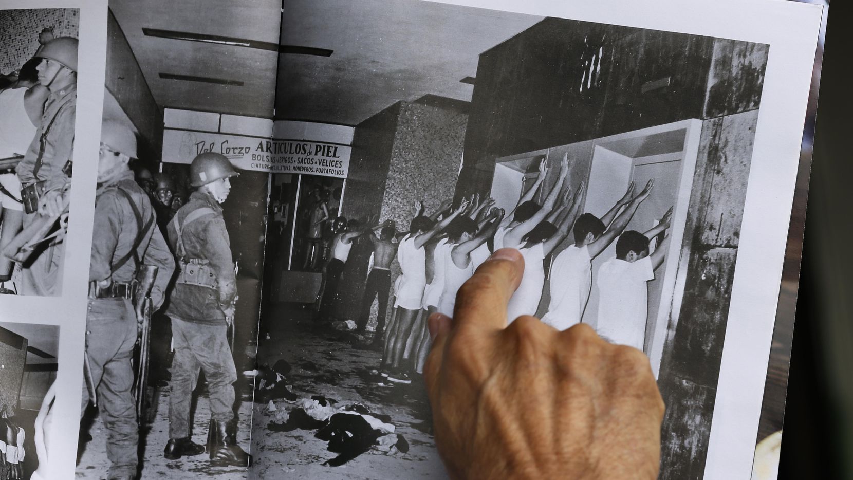 Enrique Espinoza señala una fotografía de 1968 en la cual él es detenido junto con otros...