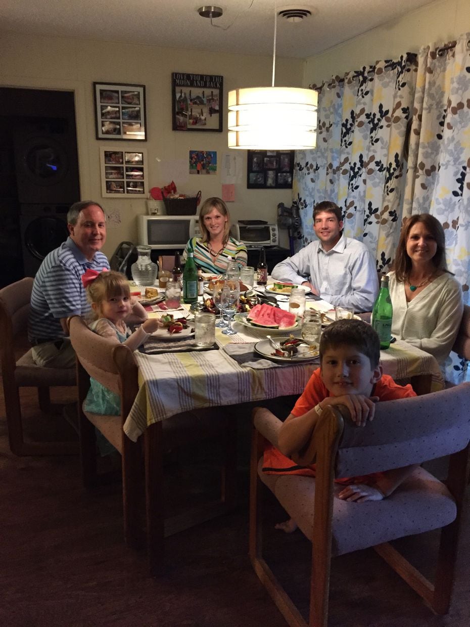 Attorney General Ken Paxton, far left, and his wife, Angela, far back, eat dinner on Thursday with the Briggles: parents, Adam and Amber; 8-year-old son MG; and 4-year-old daughter Lulu.