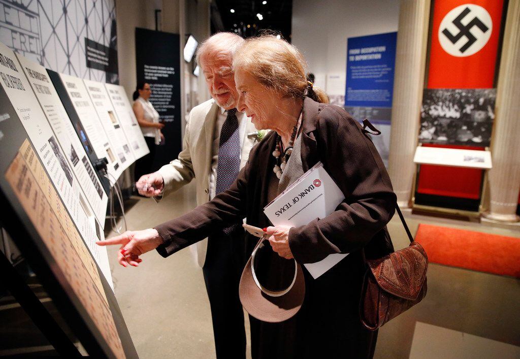 Museum docent Kathi Silver shows her husband, Charles Silver, an exhibit of badges used to...