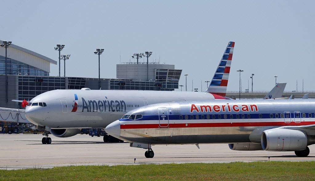 A pair of American Airlines planes taxi at Dallas/Fort Worth International Airport's...