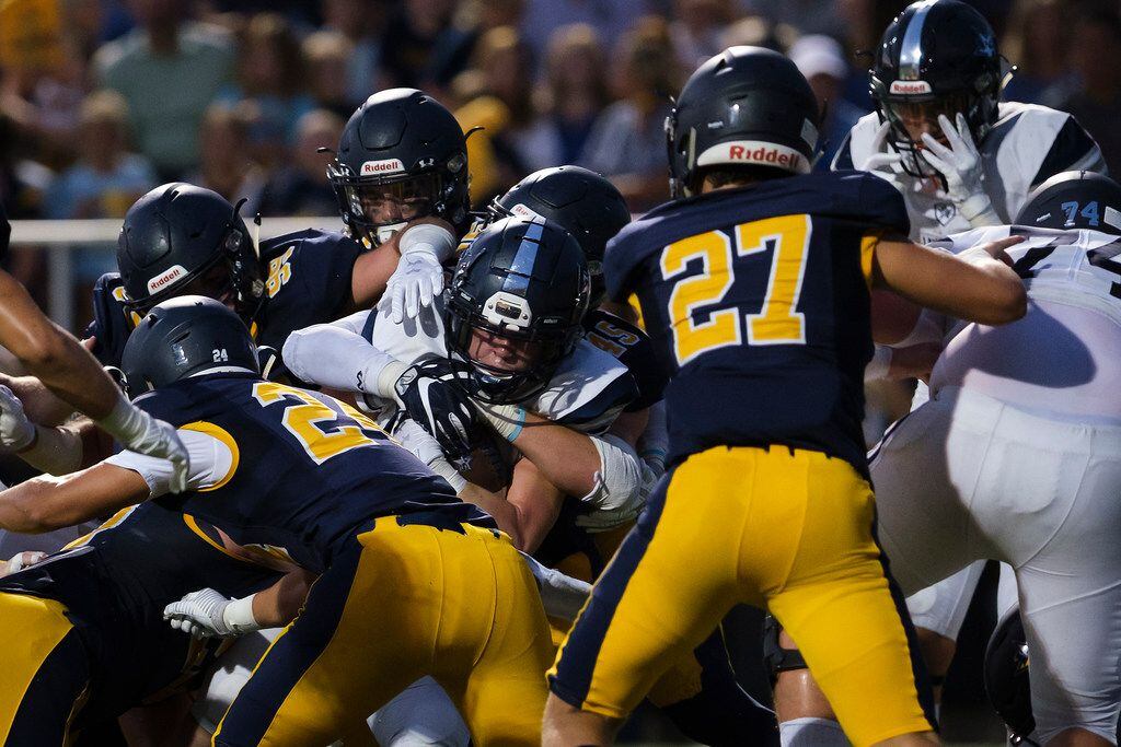 Frisco Lone Star punter Logan Claborn (2) pushes into the end zone for a touchdown past Highland Park outside linebacker John Beecherl (24) and Walker Cobb (27) during the first half of a high school football game at Highlander Stadium on Friday, Sept. 13, 2019, in Dallas. (Smiley N. Pool/The Dallas Morning News)