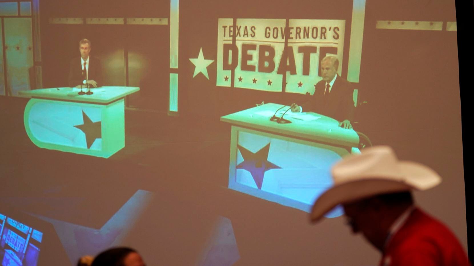 Supporters of Texas Gov. Greg Abbott watch his debate with Texas Democratic gubernatorial...