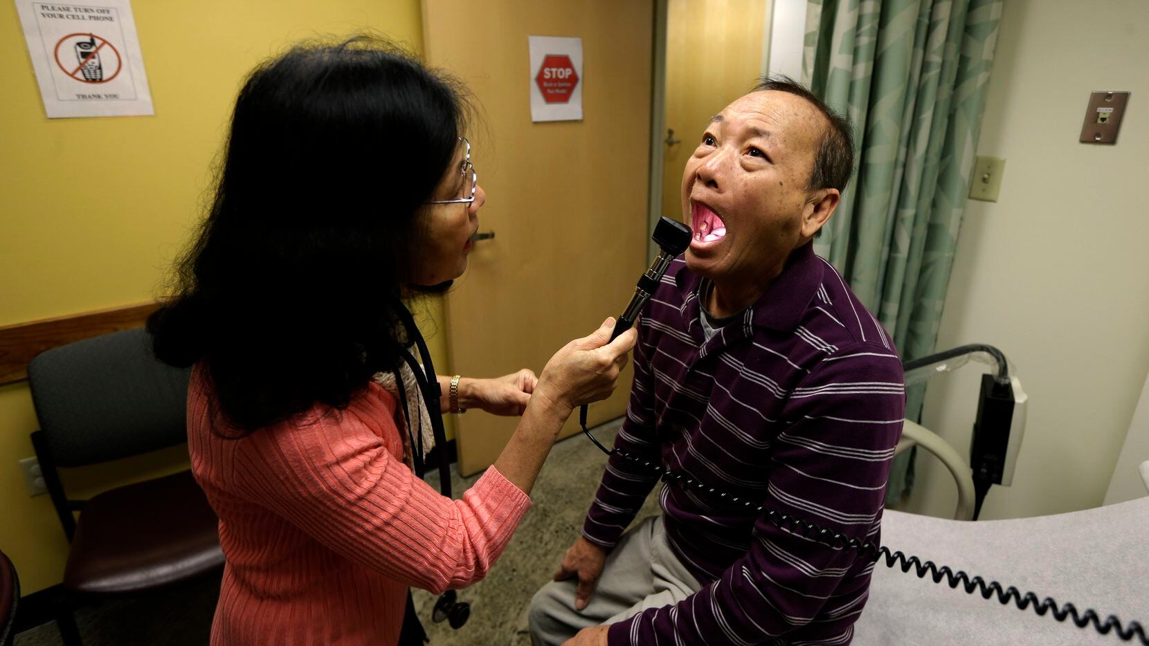 Chan Lai Ly, right, has his mouth examined as part of a regular check-up related to his...