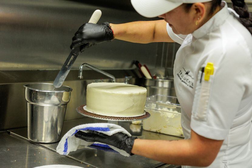 Truluck's pastry chef Paula Delgado heats a pastry spatula in hot water to smooth the cream...