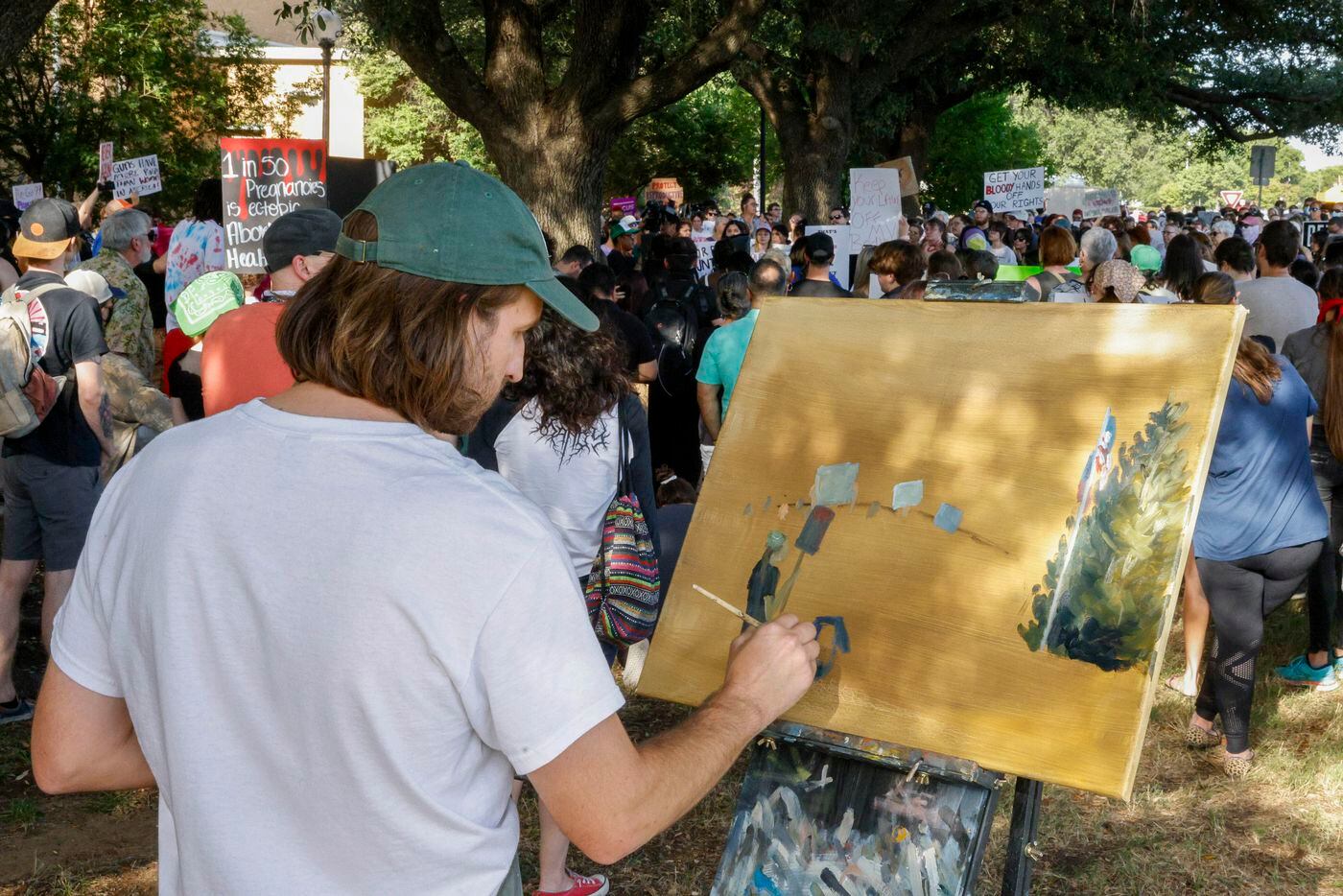 Drew Gaines, 33, paints the scene during a rally for abortion rights outside Denton City...