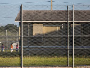 Some people are seen outside in a fenced off yard at the T Don Hutto Residential Center in...