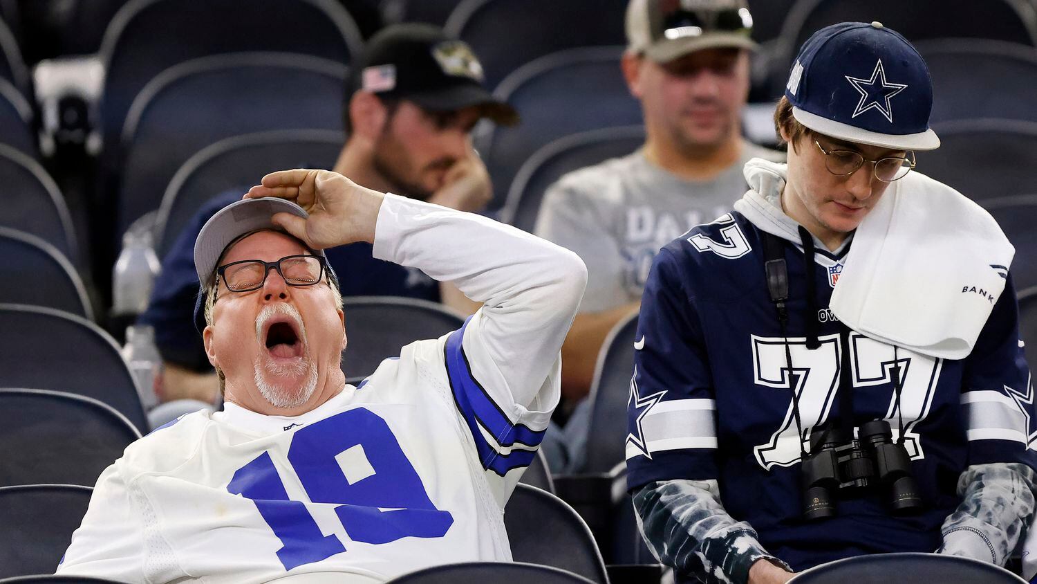 A Dallas Cowboys fan who stuck around after the NFL wild-card playoff game takes a big yawn at AT&T Stadium in Arlington, Texas, January 16, 2022. The Cowboys lost, 23-17. 