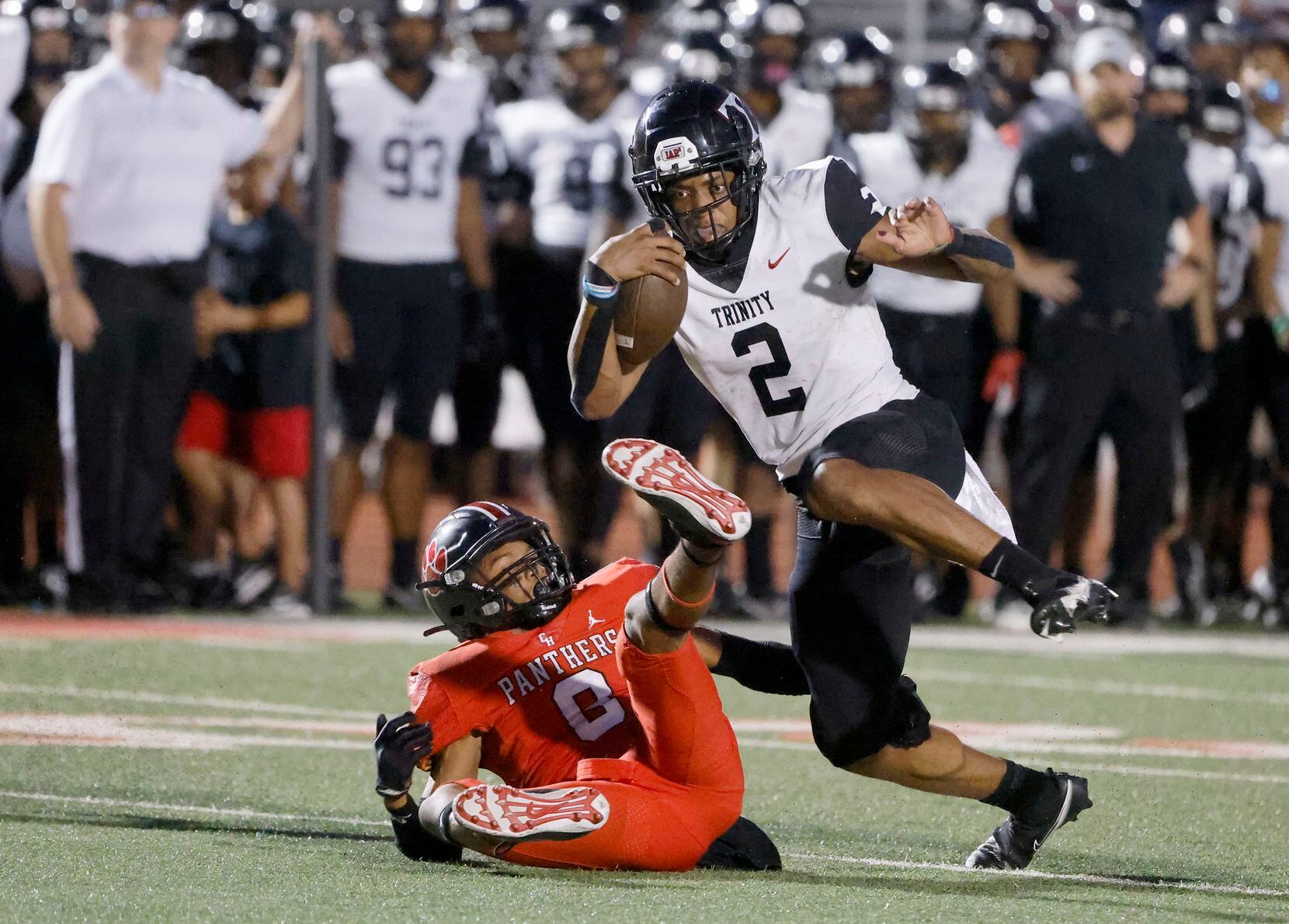 Euless Trinity quarterback Ollie Gordon (2) runs for yardage as he is defended by Colleyville Heritage player Dylahn McKinney (8) during the first half of a high school football game in Grapevine, Texas on Friday, Sept. 10, 2021. (Michael Ainsworth/Special Contributor)