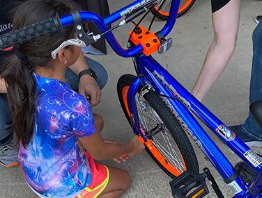 Volunteers with Golden State Foods Foundation's Frisco Quality Custom Distribution committee work with a Plano ISD student during a bike-building event. In addition to getting a free bike, volunteers talked with students about valuable life lessons.