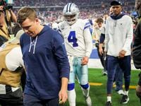 Dallas Cowboys offensive coordinator Kellen Moore and quarterback Dak Prescott leave the field following a loss to the San Francisco 49ers in an NFL Wild Card playoff football game at AT&T Stadium on Sunday, Jan. 16, 2022, in Arlington.