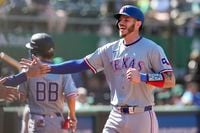 Texas Rangers' Jonah Heim celebrates after scoring against the Oakland Athletics on Travis...