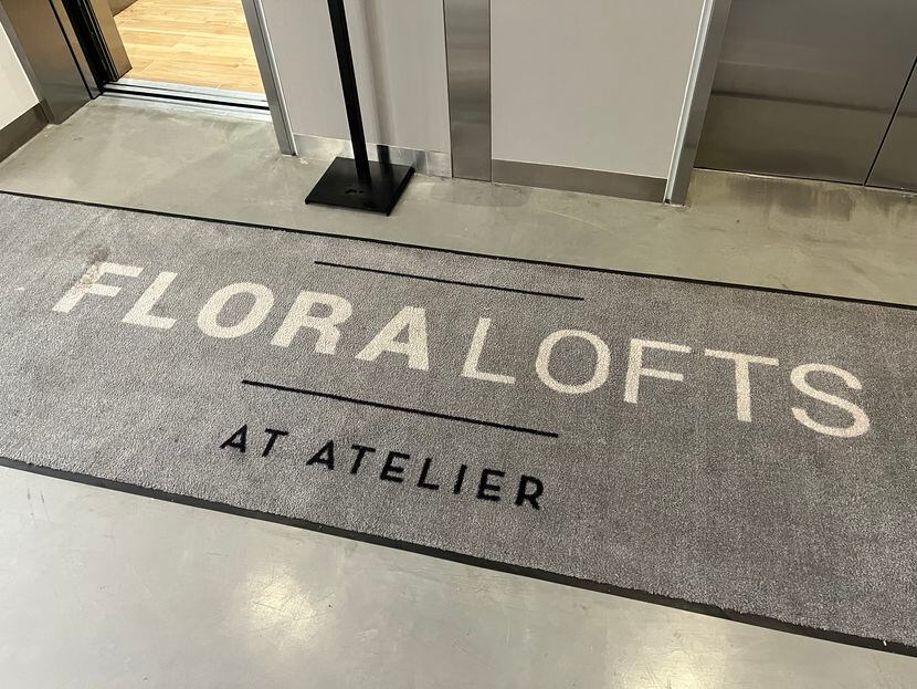 A doormat inside Atelier bears the Flora Lofts name. Its one in a handful of reminders that...