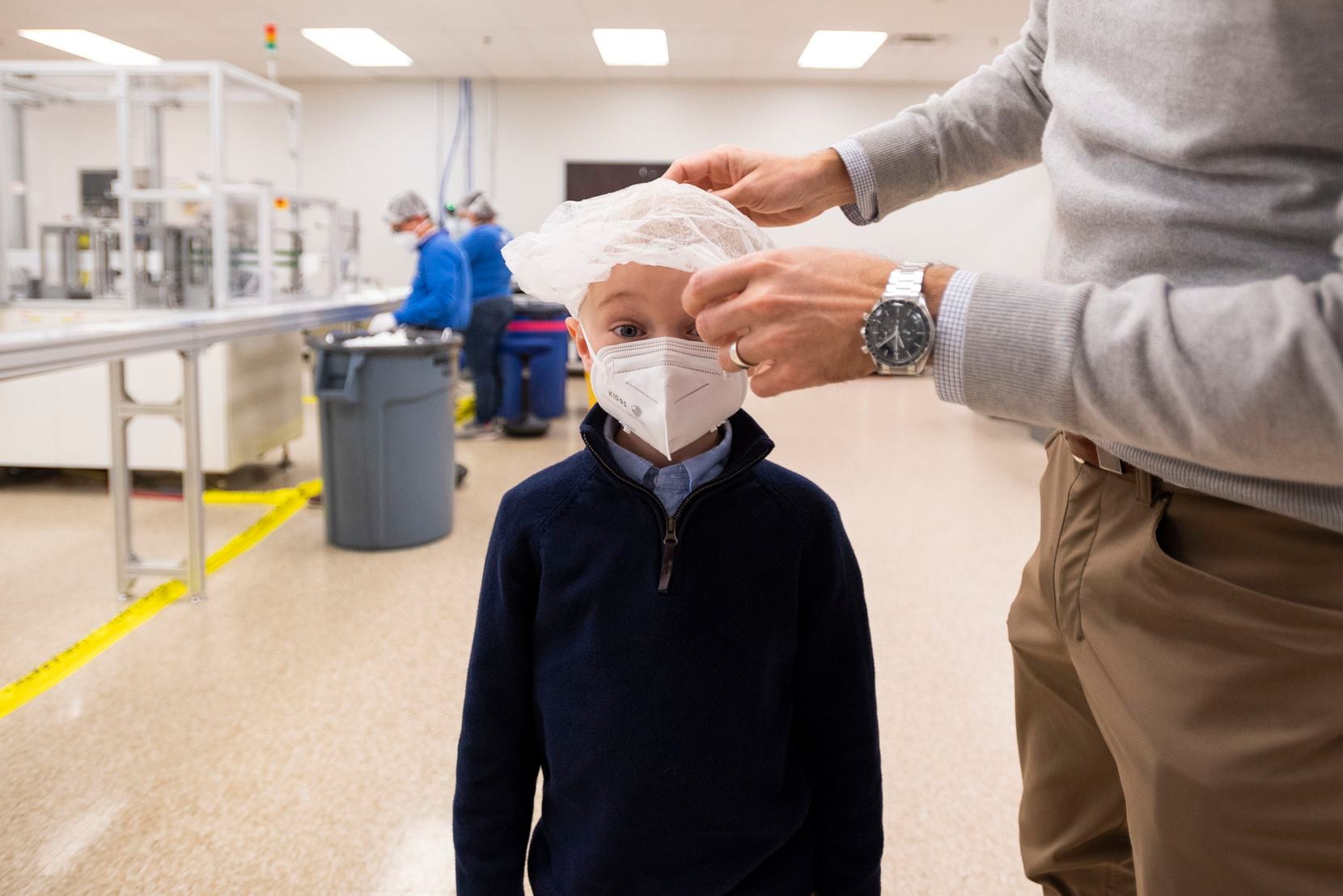 Matthew Bielamowicz, 6, wearing a KID95 mask designed for smaller faces, has a hair net...