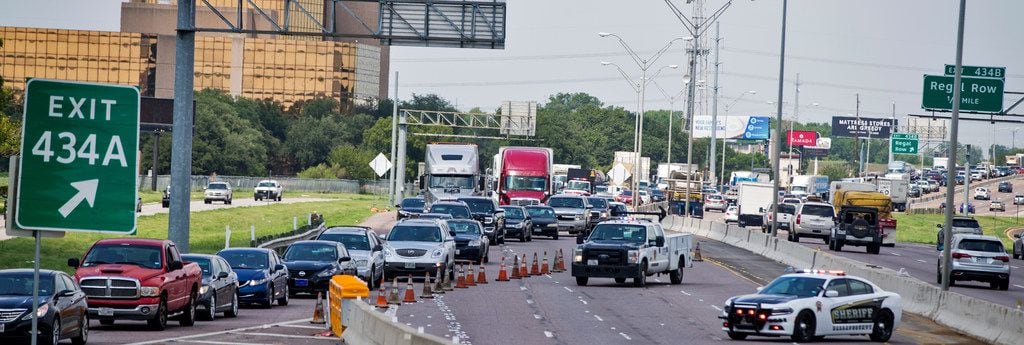 Traffic is routed off the interstate as Texas Department of Transportation employees work to clean up after a truck transporting rocks was involved in an accident on Sept. 7, 2018 on I-35E southbound in Dallas. 