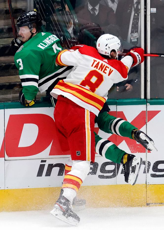 Dallas Stars defenseman John Klingberg (3) is chocked into the boards by Calgary Flames...