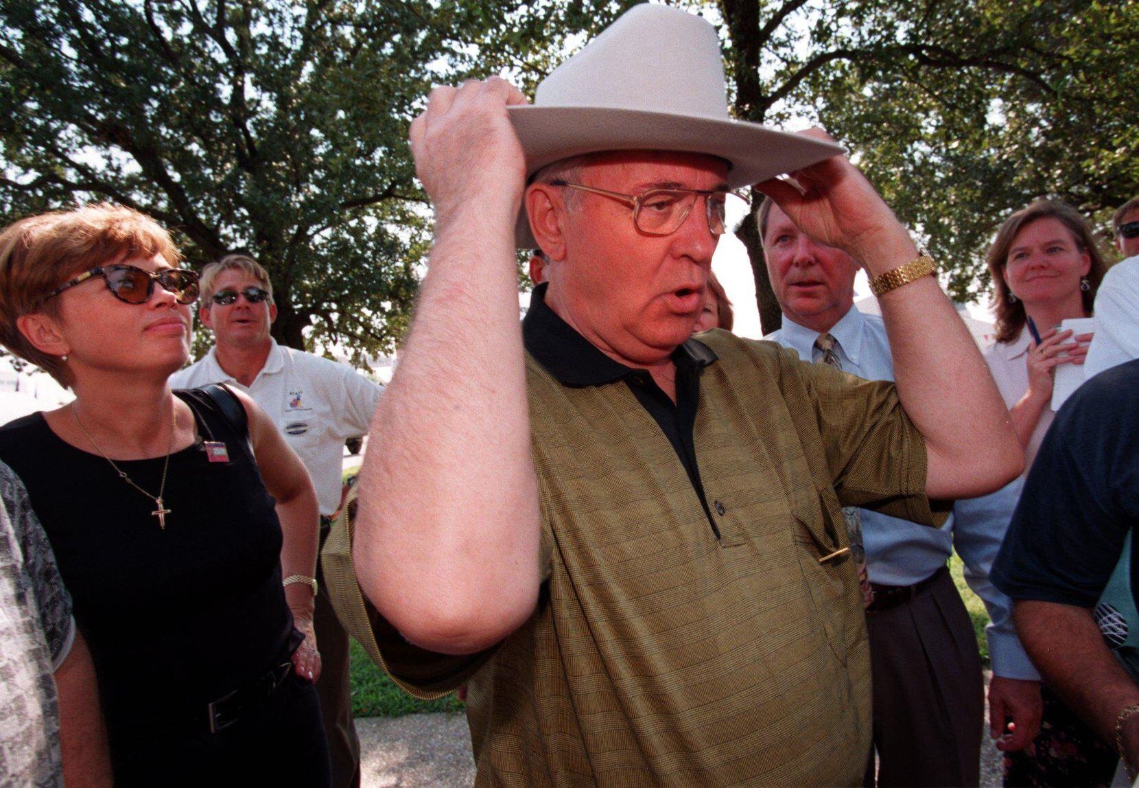 Former Soviet Union President Mikhail  Gorbachev (center) tries on a cowboy hat given to him...