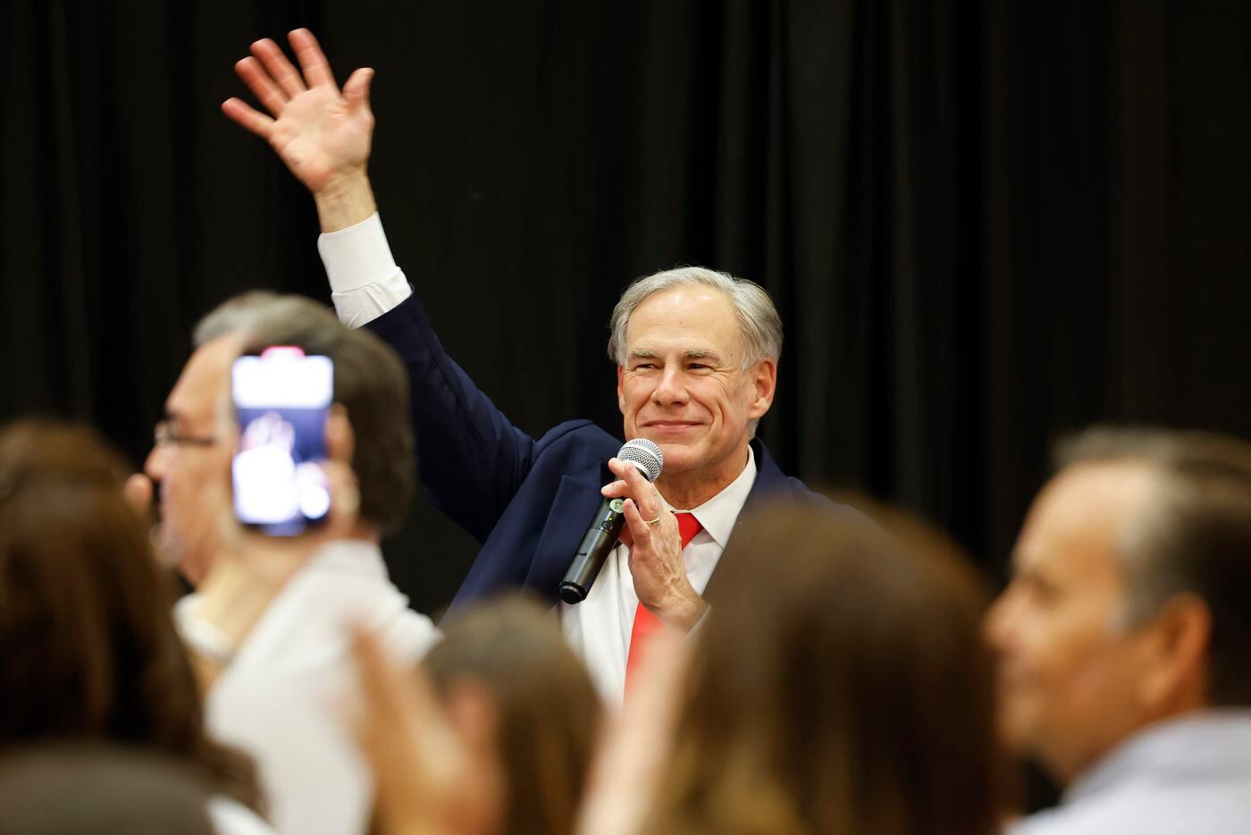 Texas Governor Greg Abbott waves towards the crowd as he arrived after his debate against...