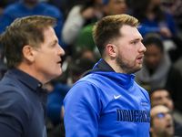Dallas Mavericks guard Luka Doncic watches from the bench with owner Mark Cuban during the...