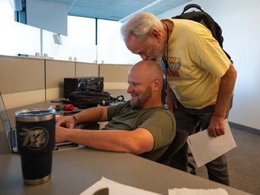 Radio legend Mike Rhyner kisses the bald head of his co-host Mike Sirois, both of the...