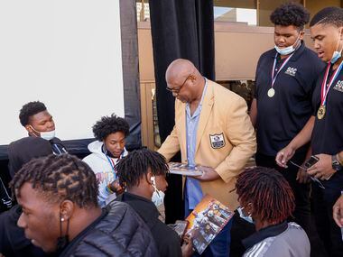 Former Dallas Cowboy Charles Haley hands out autographed photos of himself to South Oak...