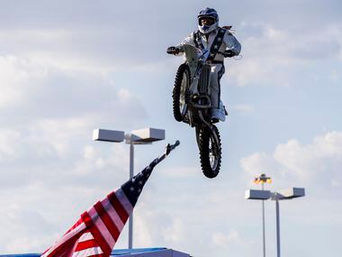 Daredevil Robbie Knievel jumps over 18 Corvettes on a motorcycle during a celebration and...
