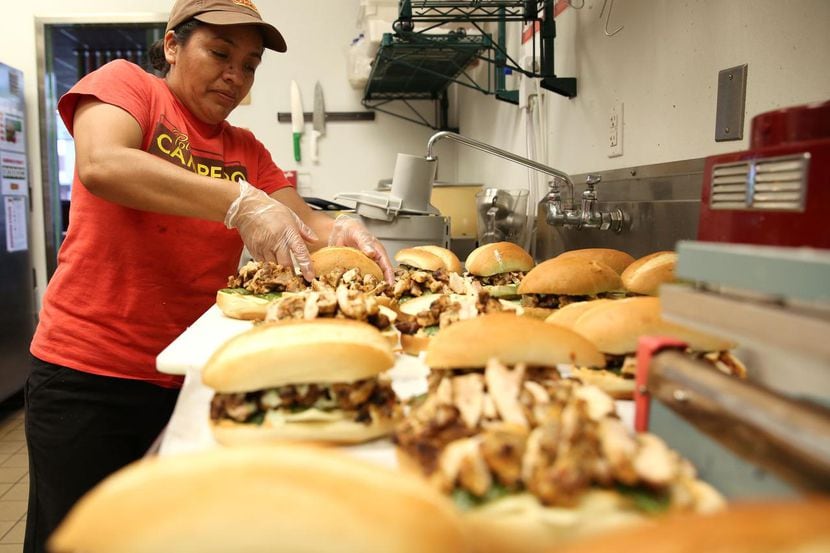 Rosalinda Domingo prepara sándwiches de pollo asado en Pollo Campero, en Dallas. (DMN/ROSE...