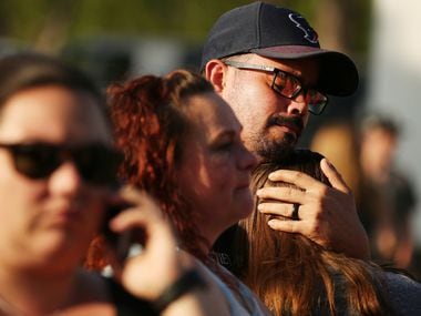 William Hunter embraces his daughter Destiny Hunter, who is home schooled, during a vigil...