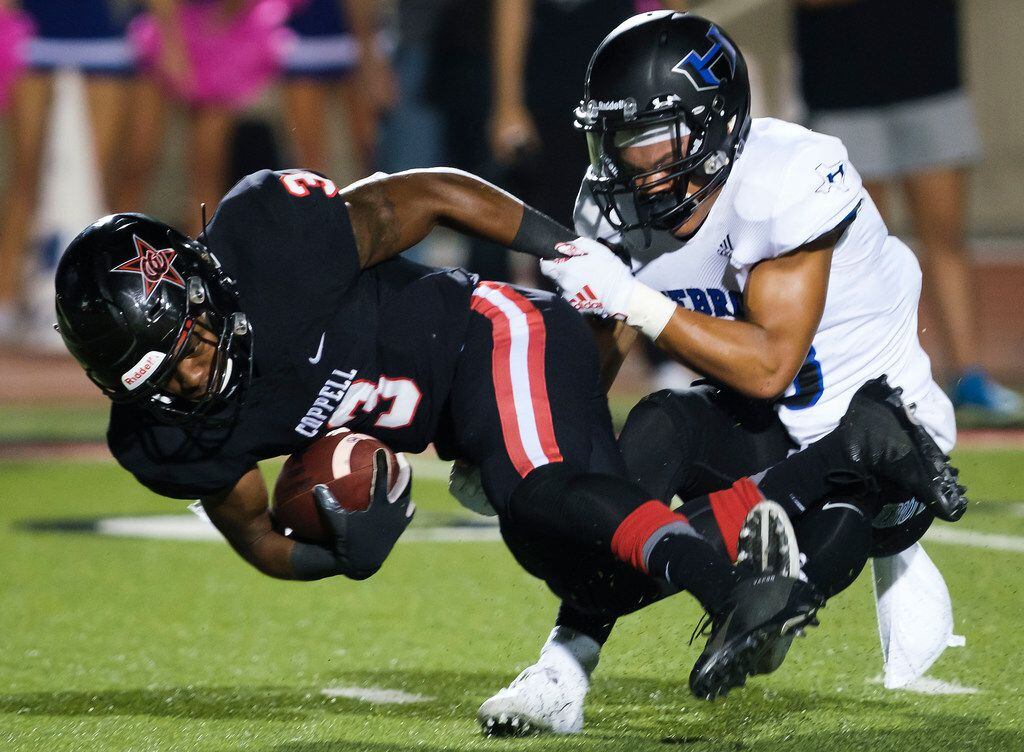 Coppell rebound Cam Williams (3) is brought down by Hebron defensive back Vinson Miller (13)...