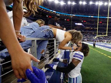 Dallas Cowboys running back Ezekiel Elliott (21) gives a close friend a kiss after their win...