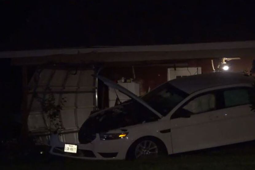 A car that struck a home in Fort Worth lies heavily damaged Thursday night.