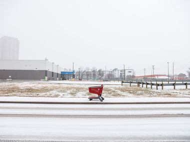 A Target shopping cart lies on the sideway at N Hall St as sleet falls over the Dallas...