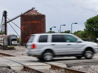 A car drives past an old silo over train tracks in Celina.