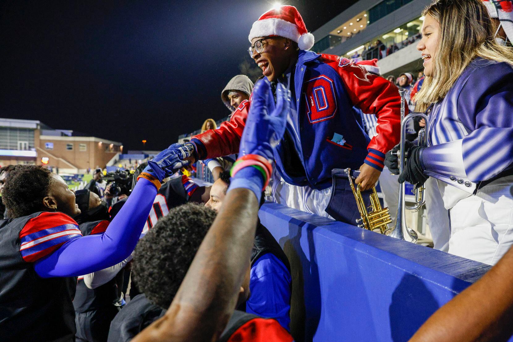 Duncanville players celebrate with band members after defeating Southlake Carroll in their...