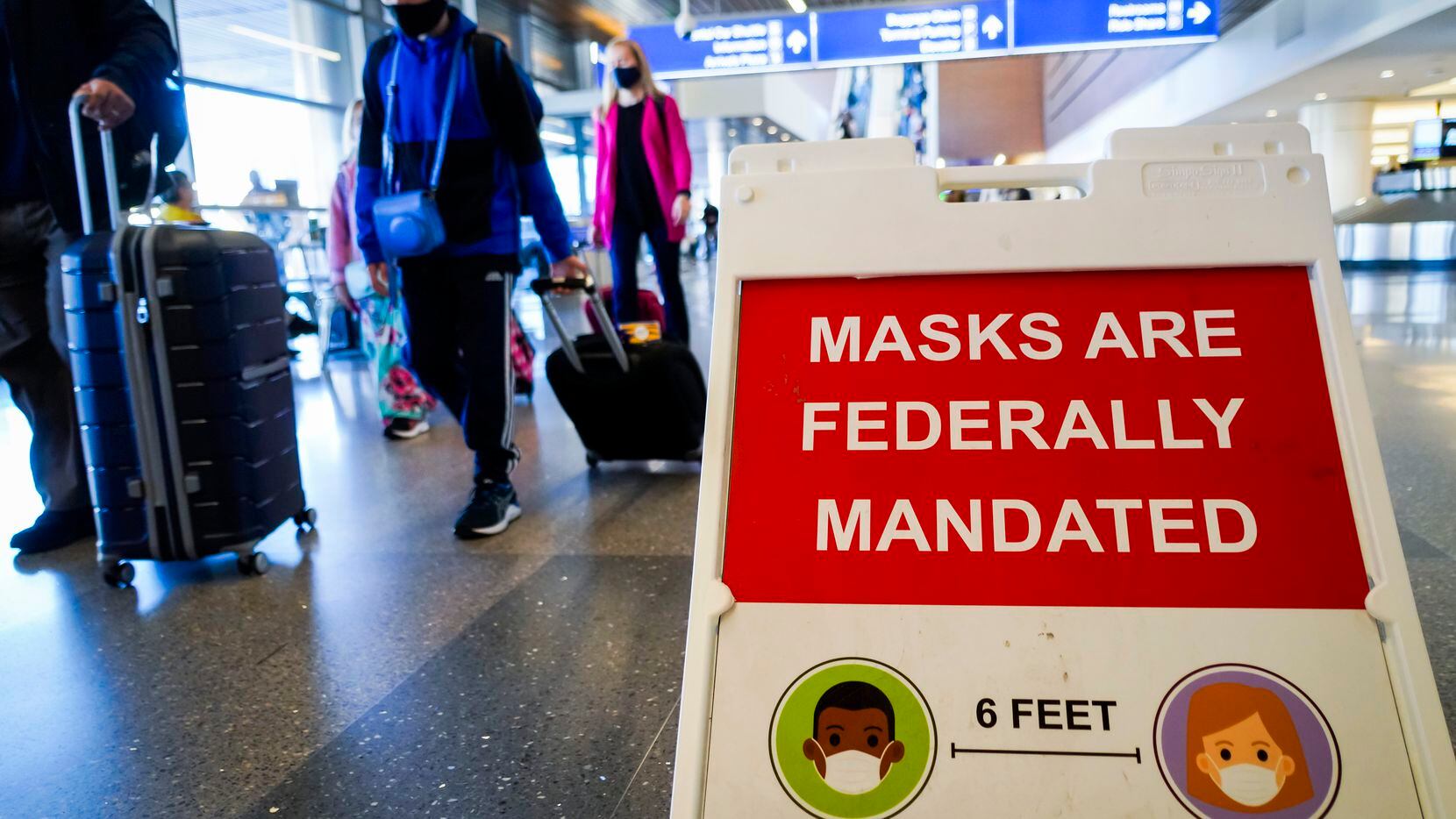 Un letrero advierte a viajeros en el Aeropuerto Internacional Phoenix Sky Harbor el mandato...