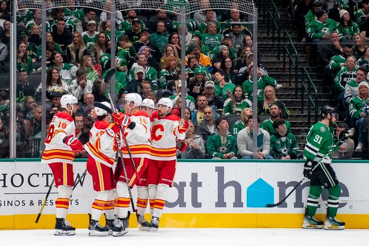 Calgary Flames players gather near left wing A.J. Greer (18) after Greer scored during the...