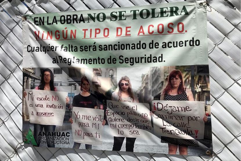 Una pancarta con mensajes en contra del acoso hacia las mujeres en una obra de construcción...