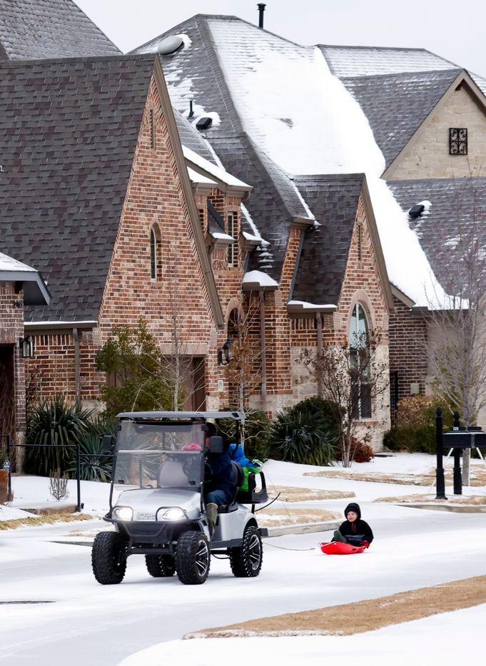 James Molaison pulls Jackson Molaison on his sled around the sleet-covered streets in a...