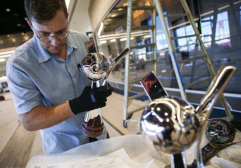 Art handler Bob Treece prepares a trophy case display at the National Soccer Hall of Fame,...