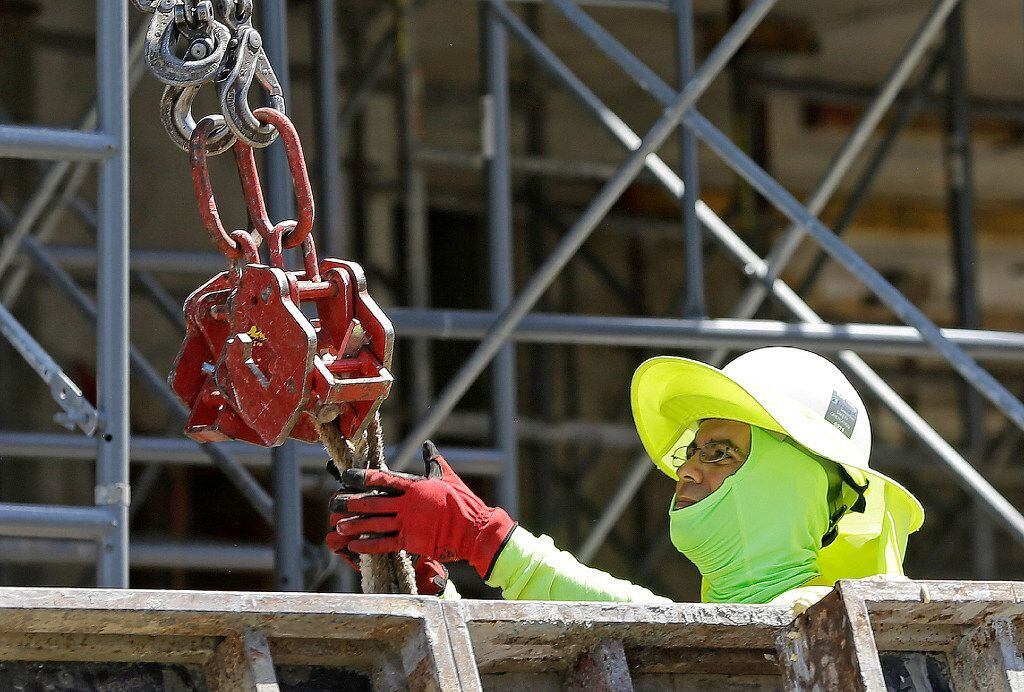 A construction worker stays busy at a condominium project in Coral Gables, Fla.