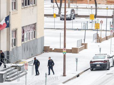 Dallas Police officers enter the CIty of Dallas Municipal Court as sleet covered Commerce St...